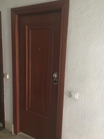 Piso en Valencia. Puerta acorazada y Armarios con puertas blancas correderas.